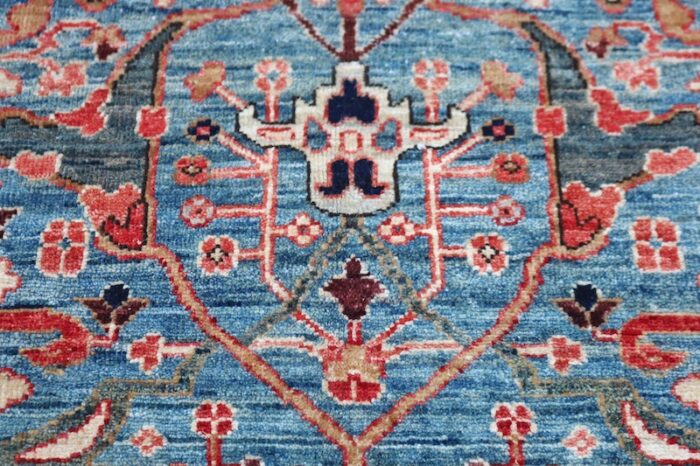 5x7 handmade Ziegler wool rug featuring intricate geometric patterns in sky blue, navy, and rust red