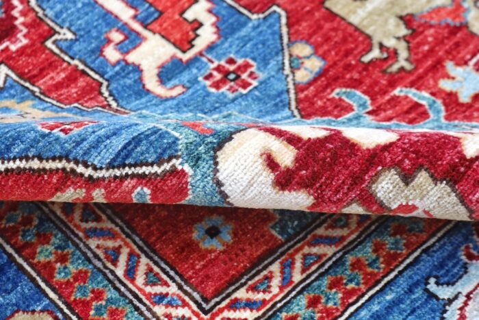 Traditional Persian-style area rug with a rich red field, sky blue accents, and a detailed deep blue border