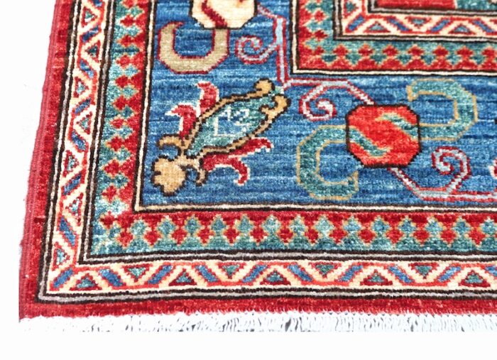 Luxury handwoven wool rug with vibrant red, blue, ivory, and gold tones, perfect for living rooms and dining spaces