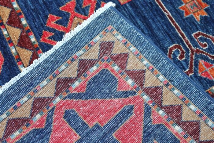 Handwoven 8x10 Kurdish rug with deep navy blue background and bold tribal patterns