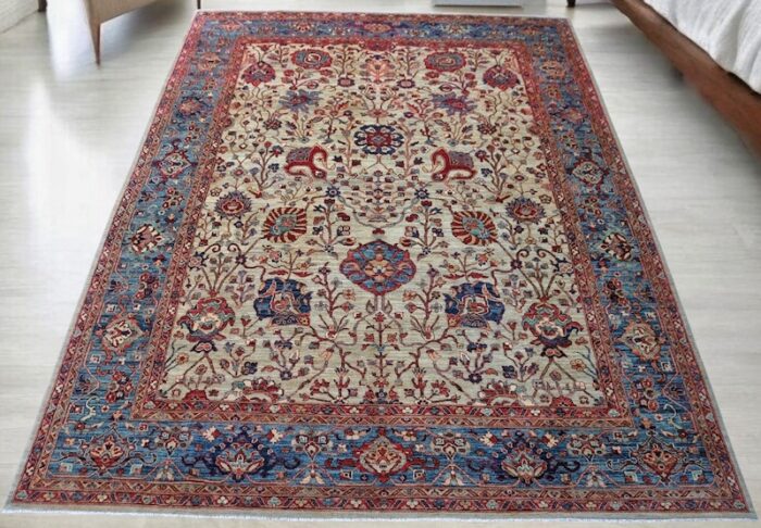 Handwoven 9x12 Persian Tehran rug with ivory background and intricate floral motifs.