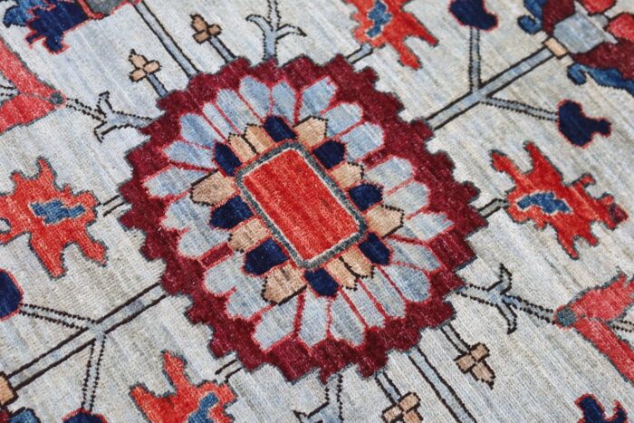 Handwoven 9x12 Persian Serapi rug with light blue background and intricate floral motifs.