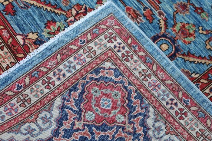 Handwoven 9x12 Persian Heriz rug with sky blue background and bold medallion design.