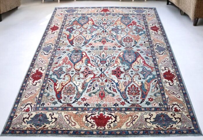 Handwoven 9x12 Turkish Oushak rug with sky blue background and floral motifs.