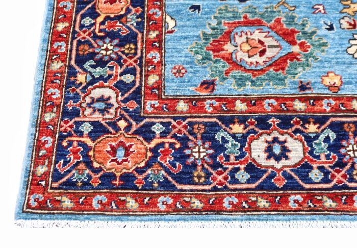 5x7 handmade Persian Heriz wool rug with tribal geometric patterns in sky blue, navy, and rust red