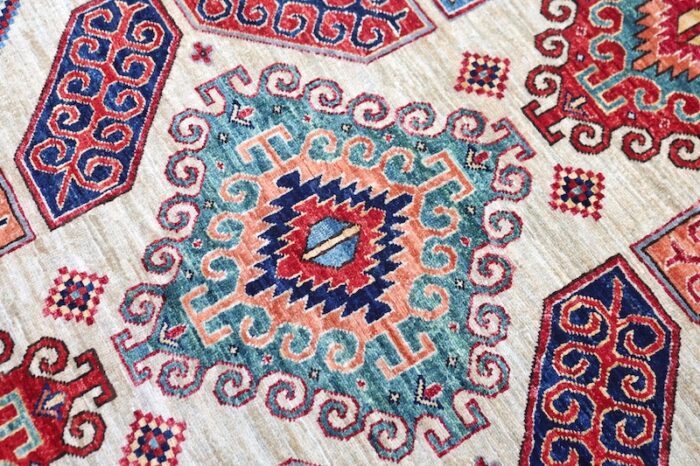 Washable wool Kazak rug with geometric designs in sky blue, ivory, and deep red hues