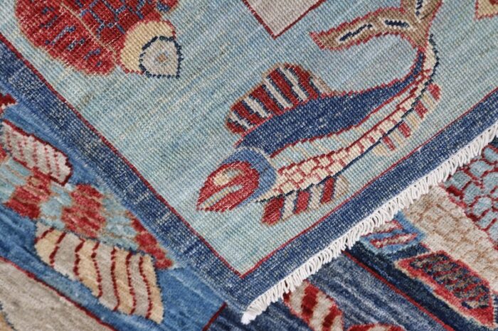 Artistic fish design wool rug with a nautical theme, deep blue background, and red striped fish, size 4'11 x 6'10."