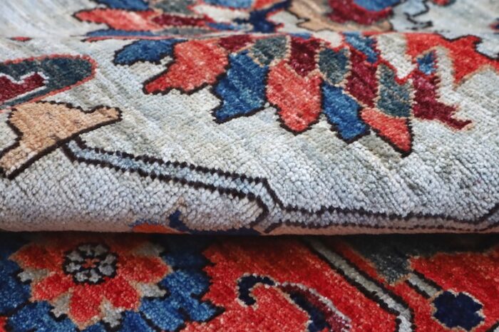 Hand-knotted Serapi Persian rug with soft blue, red, and ivory tones.