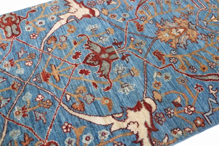 Hand-knotted wool Persian runner rug featuring intricate floral and tribal designs