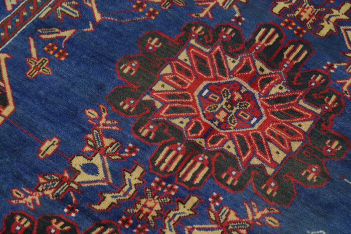 Handwoven Afghan Baluch rug 6'6 x 4'1 ft with deep navy blue background and vibrant red geometric medallion patterns. Washable and durable wool rug