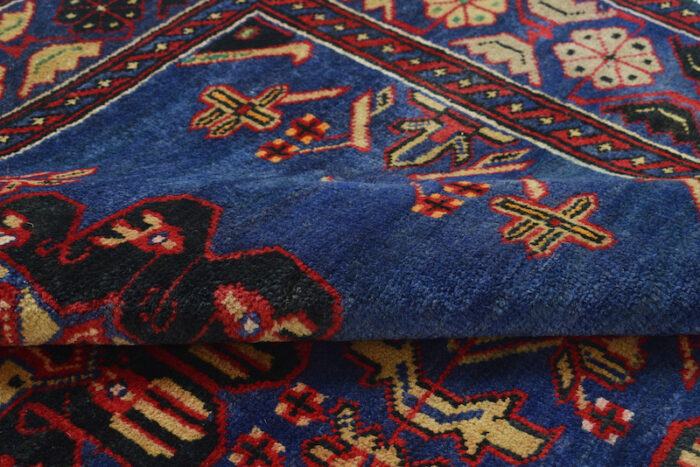 Traditional Afghan wool rug with geometric and floral patterns in deep blue, ivory, and rust. High-quality craftsmanship and stain-resistant."