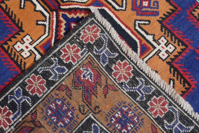 Village-made Afghan wool rug with a traditional tribal design in blue, rust, and black. Durable, washable, and long-lasting